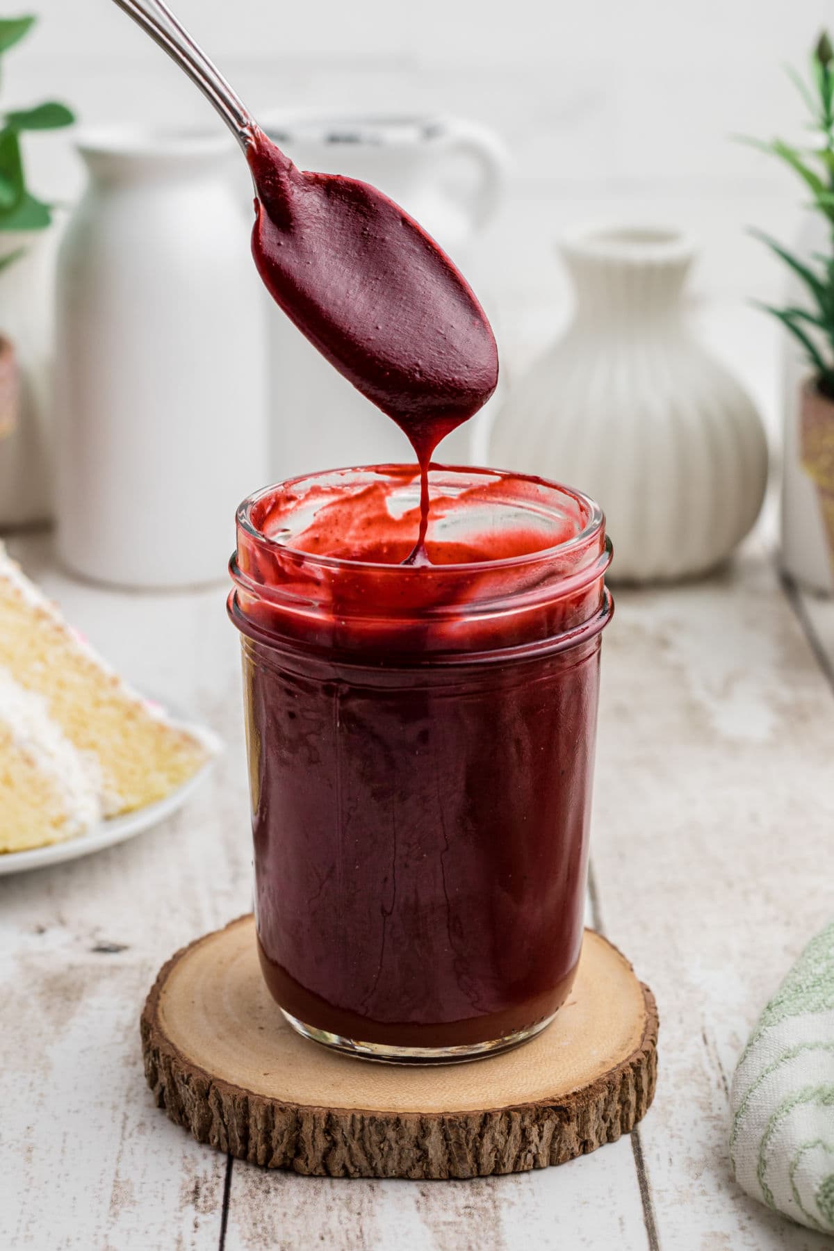 Red velvet hot fudge sauce being spooned into a jar.