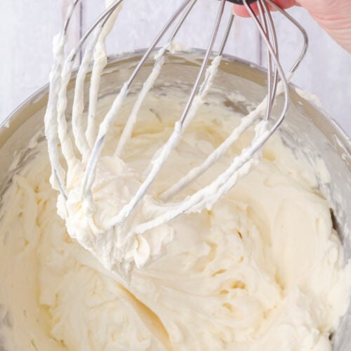 A closeup of cream cheese frosting on the beater.