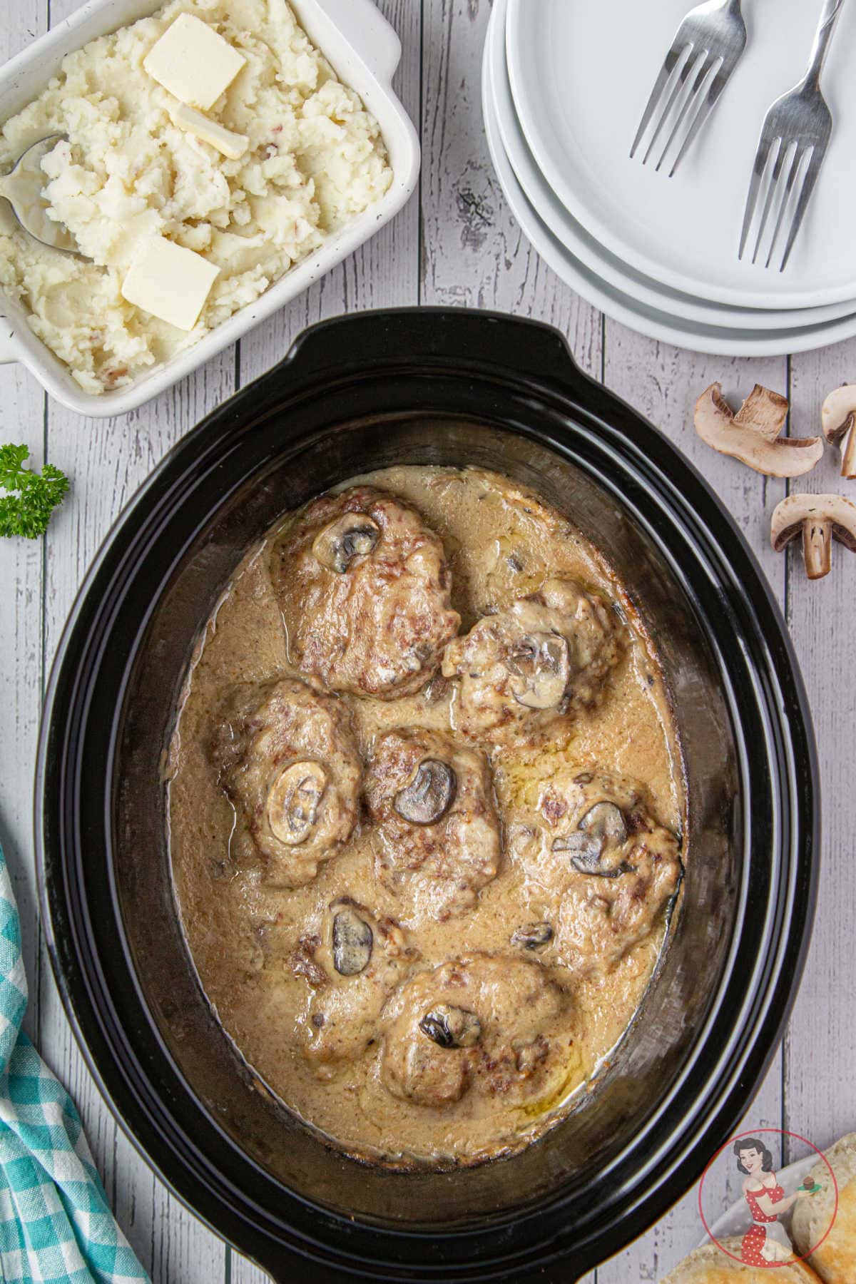 Overhead view of a slow cooker full of meat and gravy.