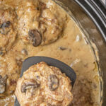 Overhead view of the steaks in a slow cooker with a text overlay for Pinterest.