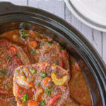 Overhead view of the slow cooker filled with swiss steak and a text overlay for Pinterest.