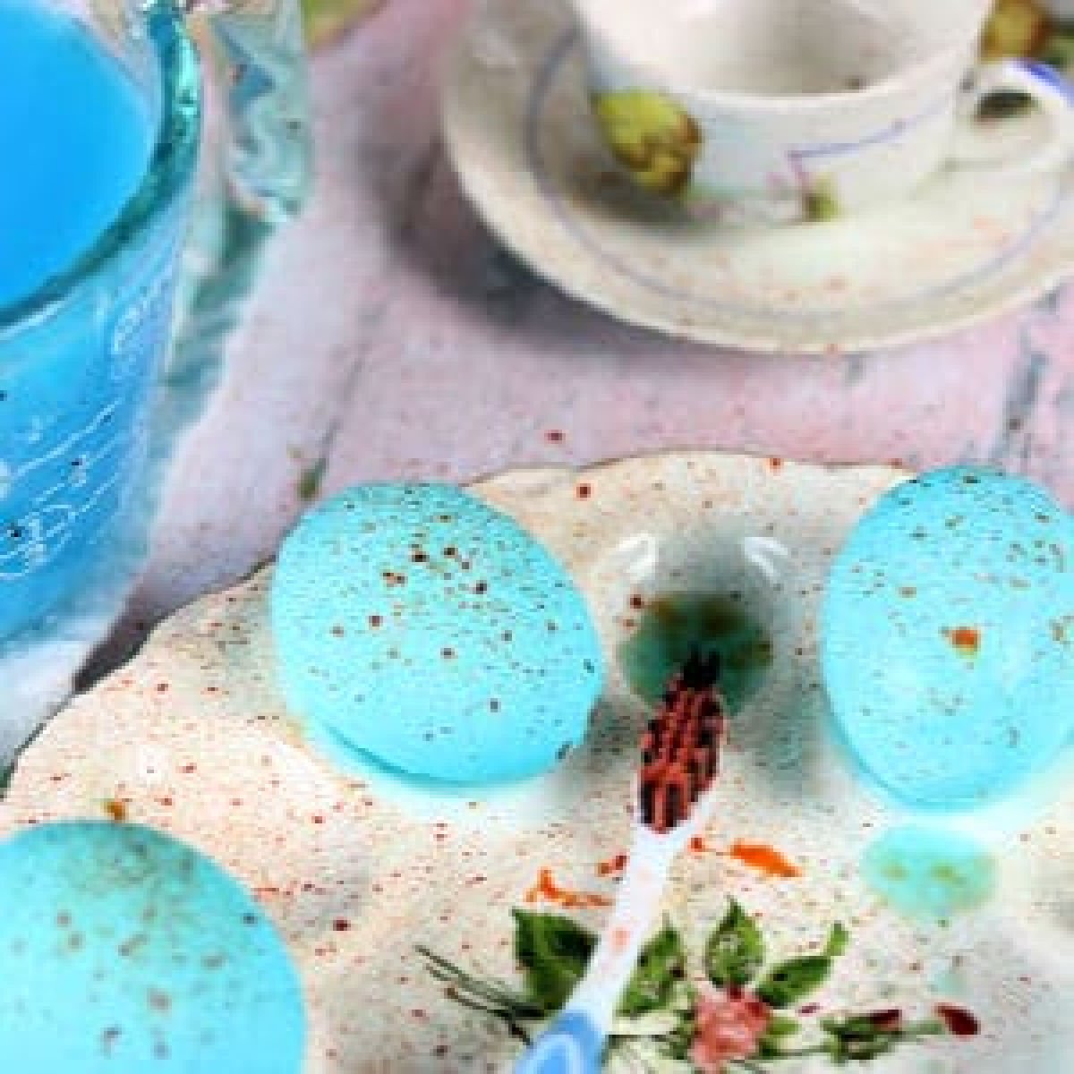 Blue eggs speckled with brown drying in an egg dish.