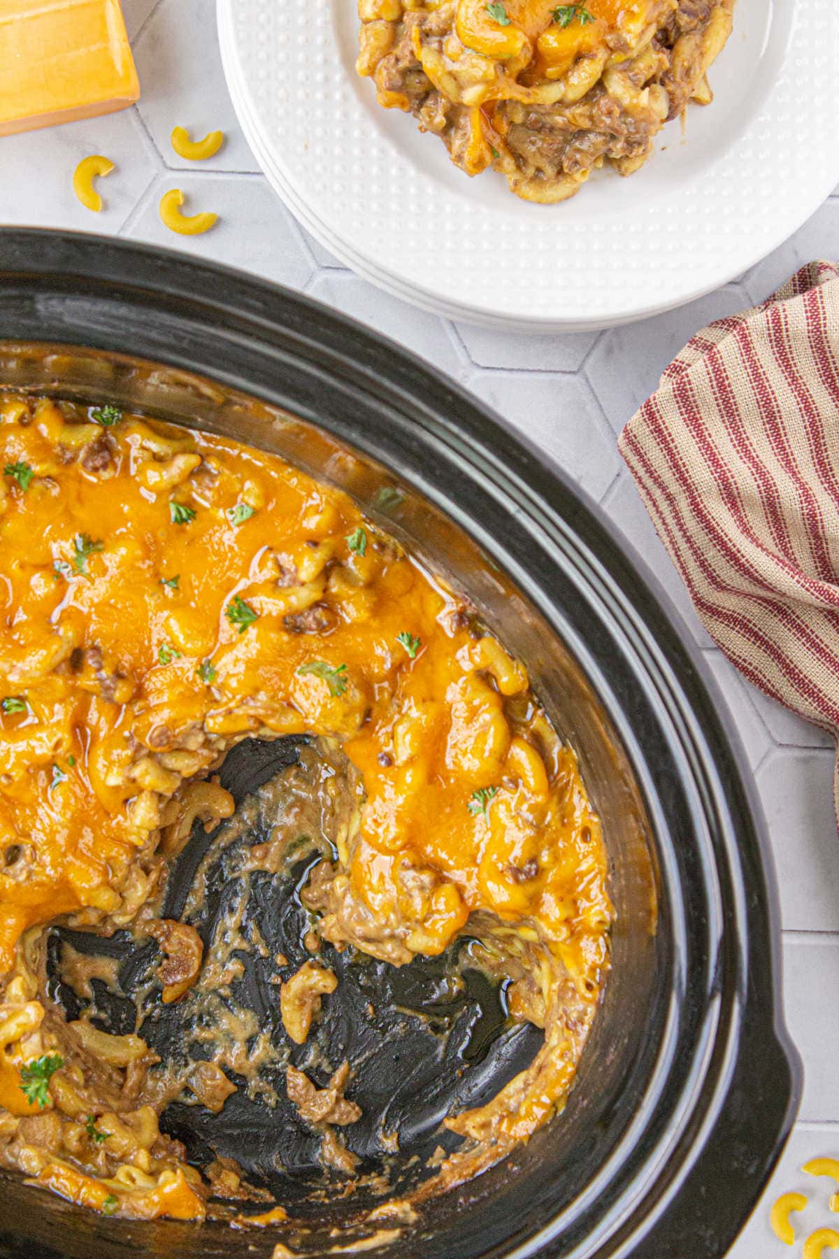 A crockpot with some of the casserole gone.