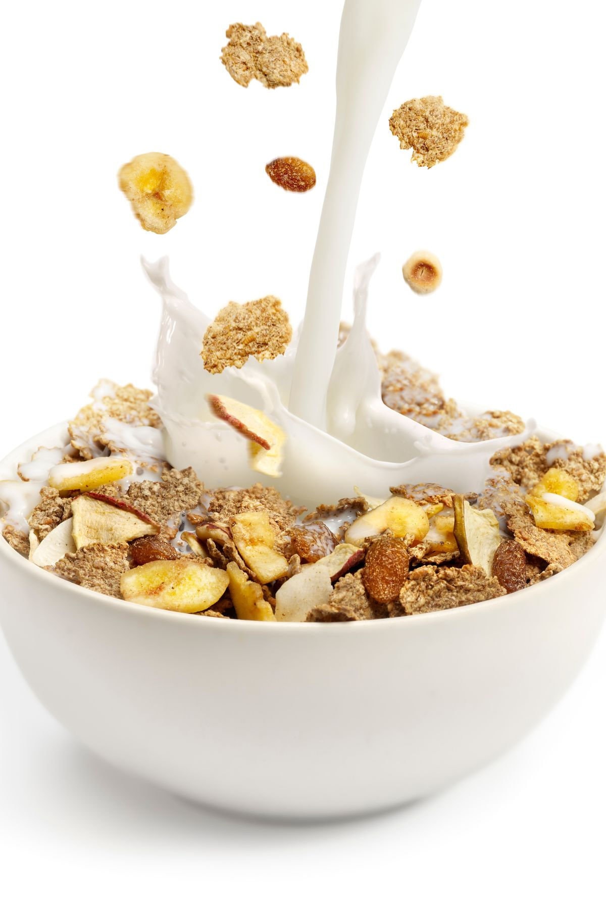 Milk being poured into a bowl of cereal.