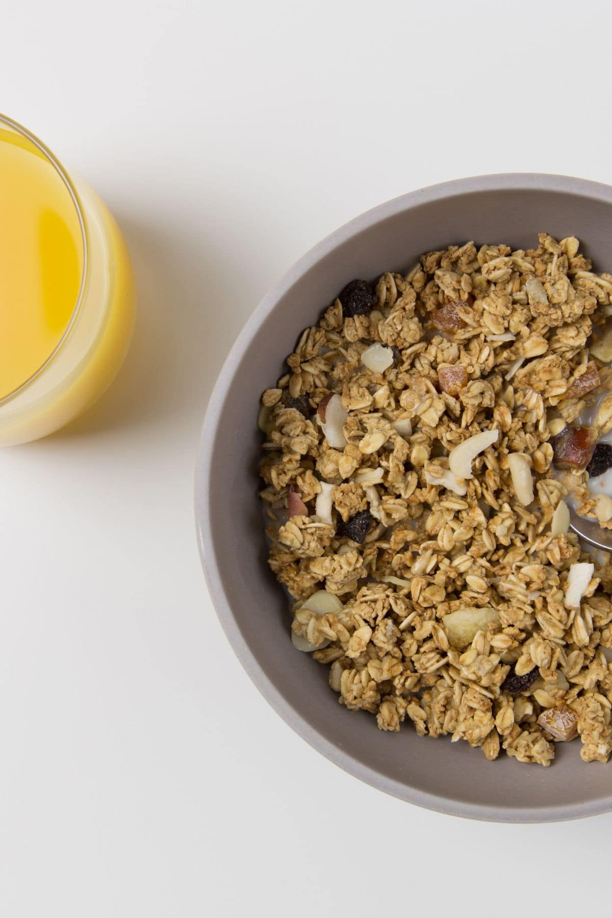 A bowl of cereal and orange juice.