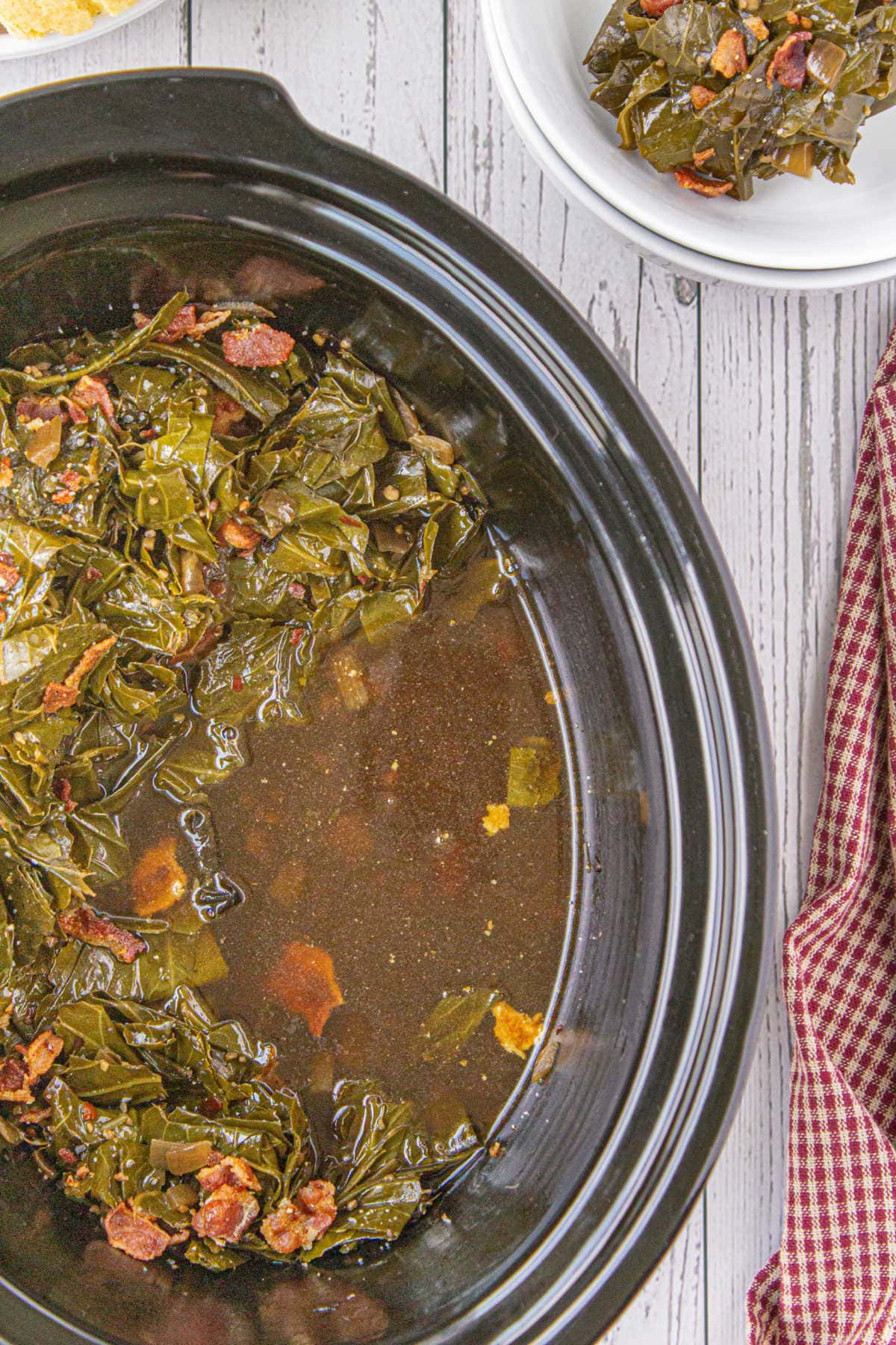 Overhead view of the interior of the slow cooker with the finished greens in it.