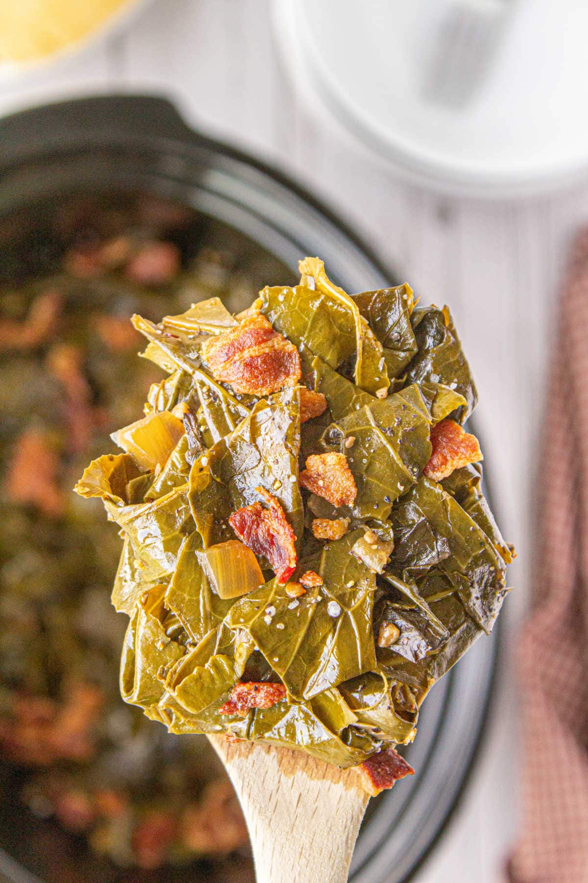 A serving of greens being spooned from the slow cooker.