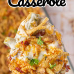 A spoonful of creamy casserole with crispy onions on top being served.