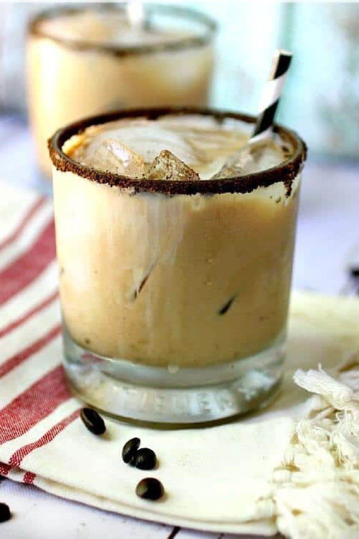 A coffee cocktail in a glass with a ground coffee rim.