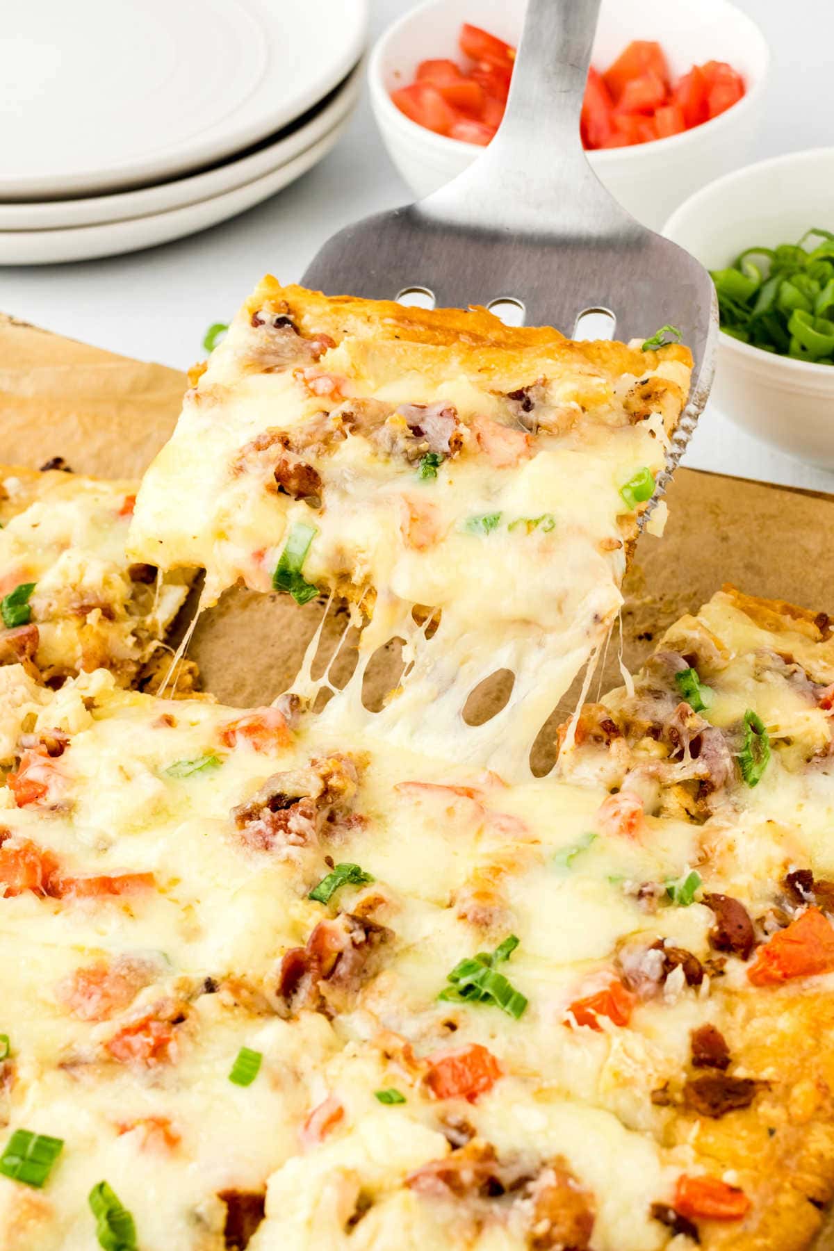 A slice of pizza being removed from the pan showing the rich, melty cheese.