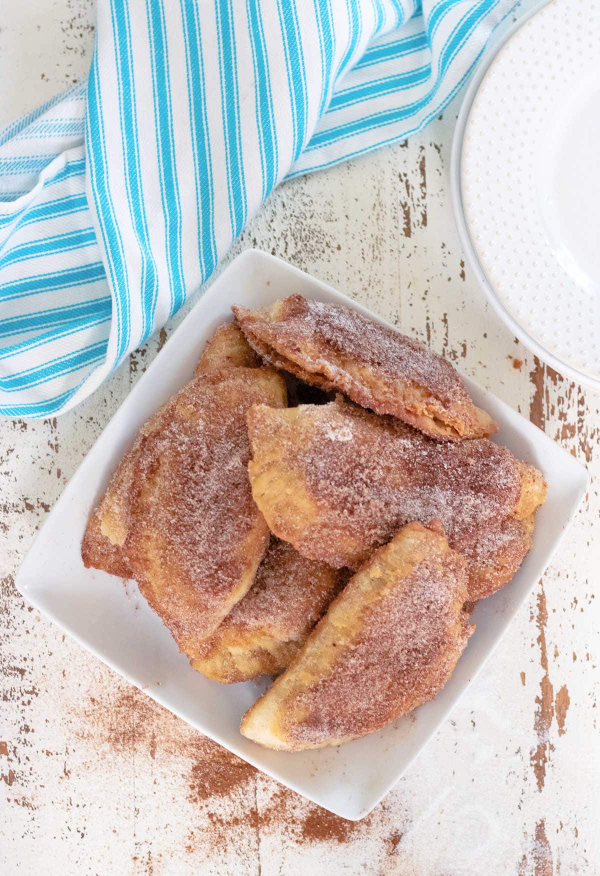 Overhead view of fried pies sprinkled with cinnamon.