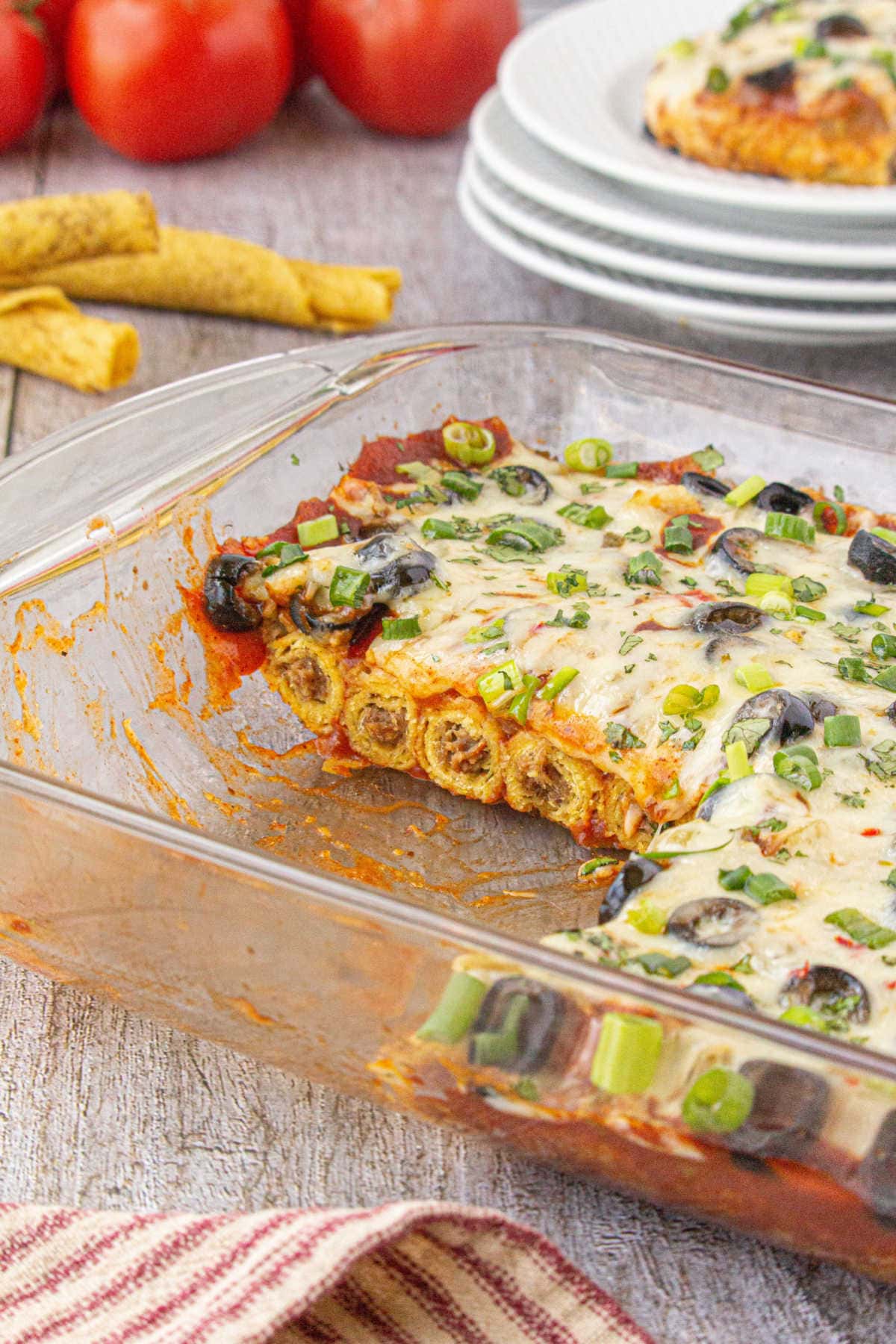 The casserole in a glass dish with a serving removed showing the layers in the interior.