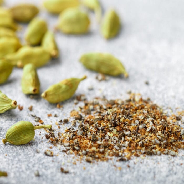 Ground cardamom and cardamom seed on a table.