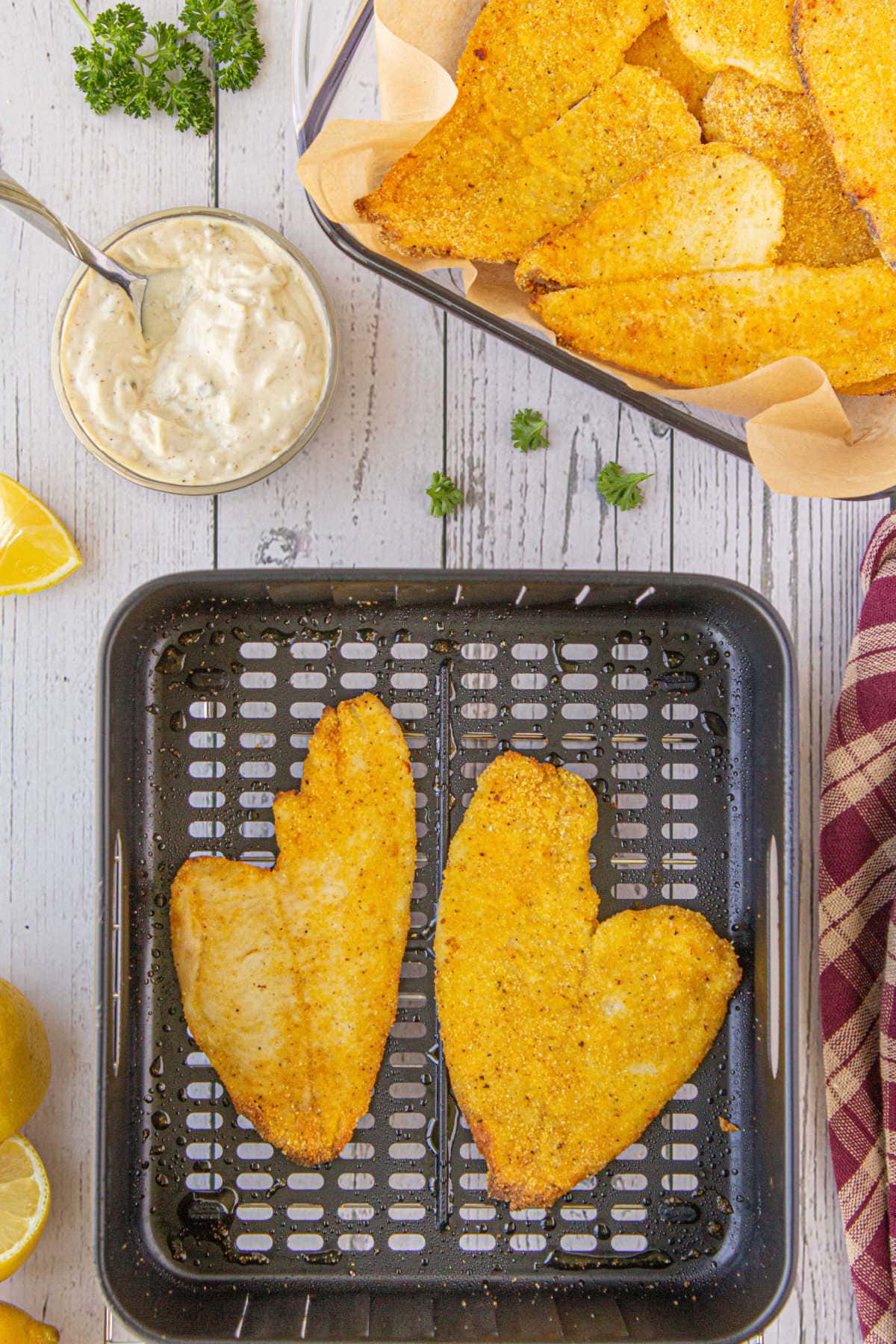 Overhead view of golden fried catfish in an air fryer basket.