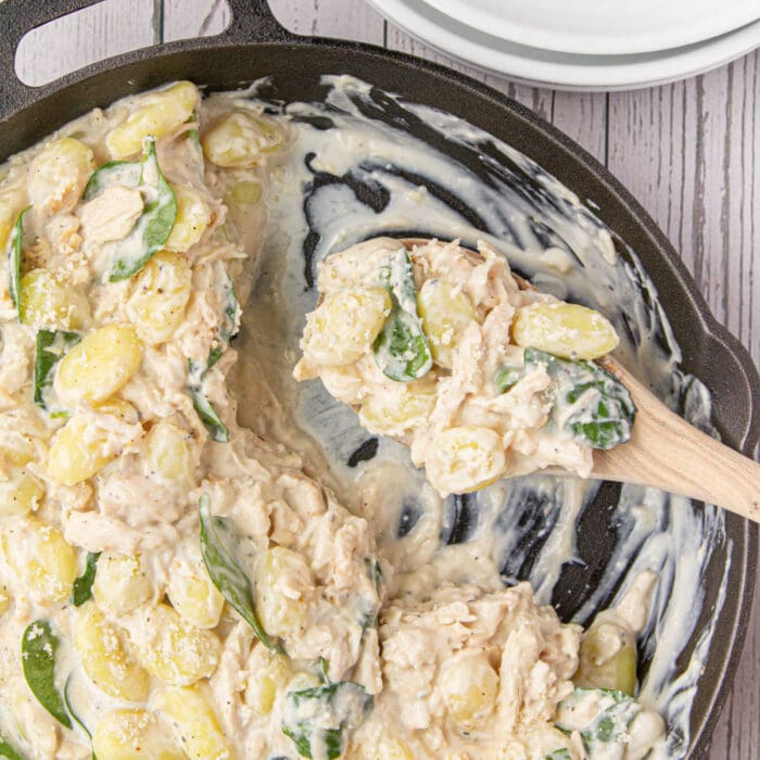 Closeup of creamy chicken gnocchi in an iron skillet.