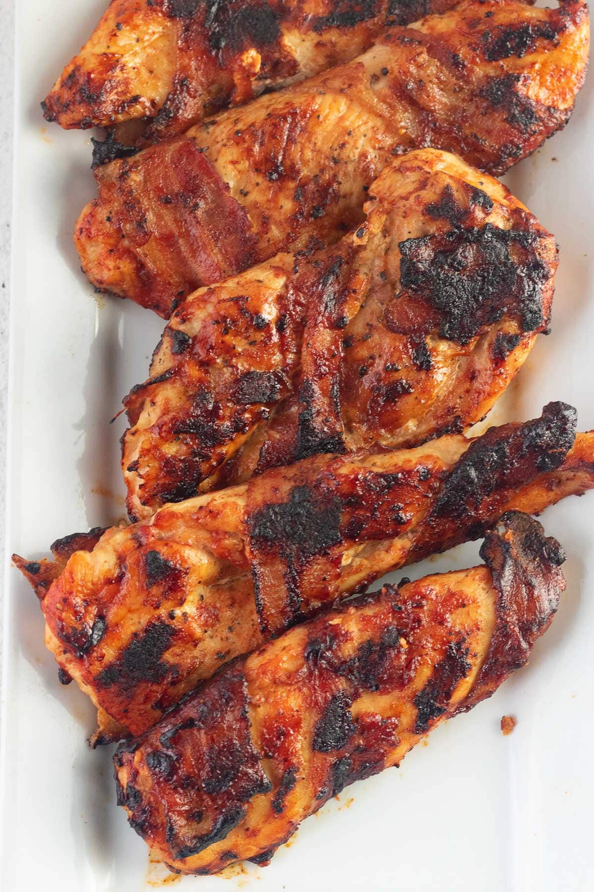 Overhead view of grilled chicken on a white plate.