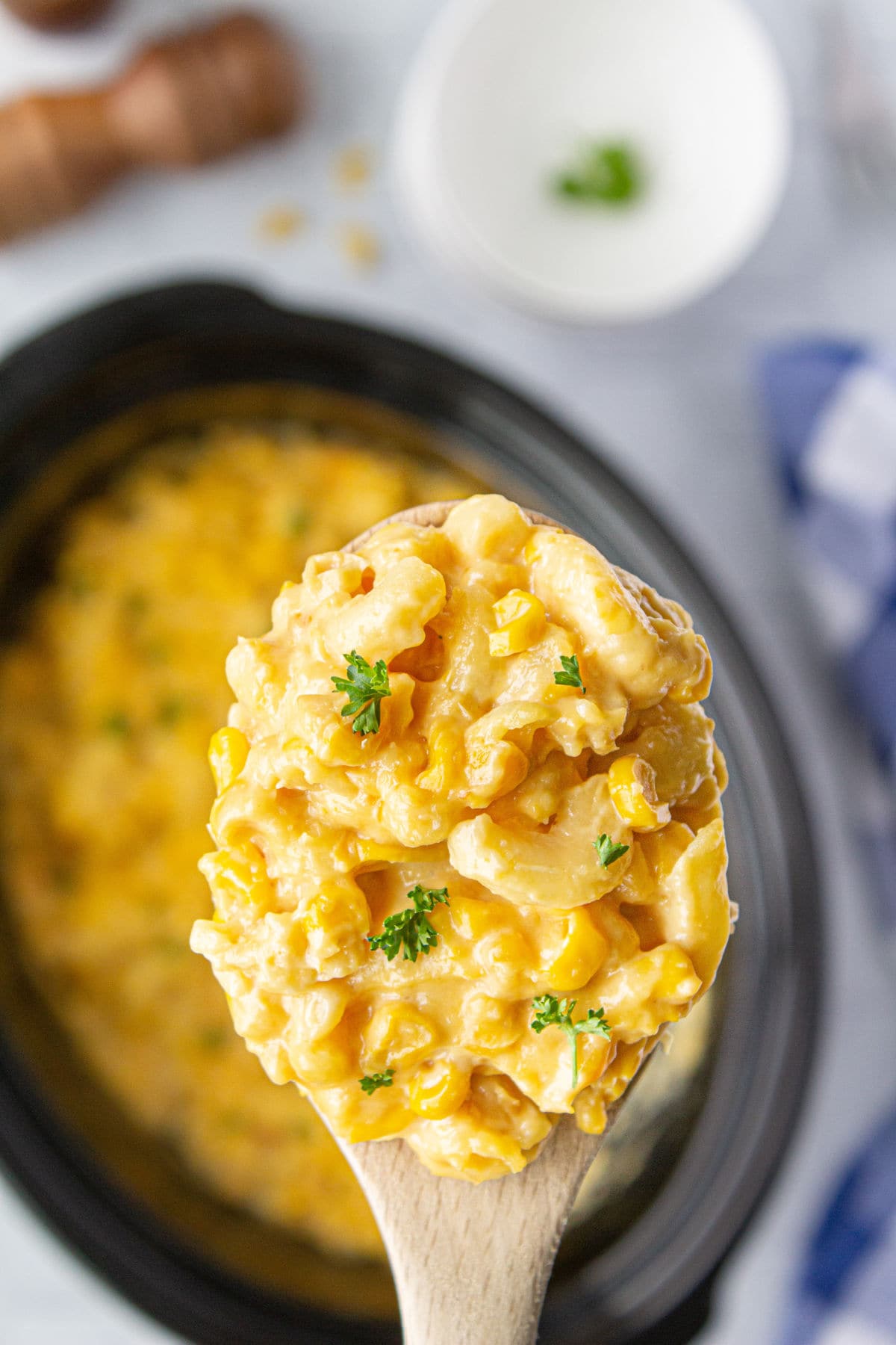 Crock pot macaroni and corn casserole in a serving spoon.