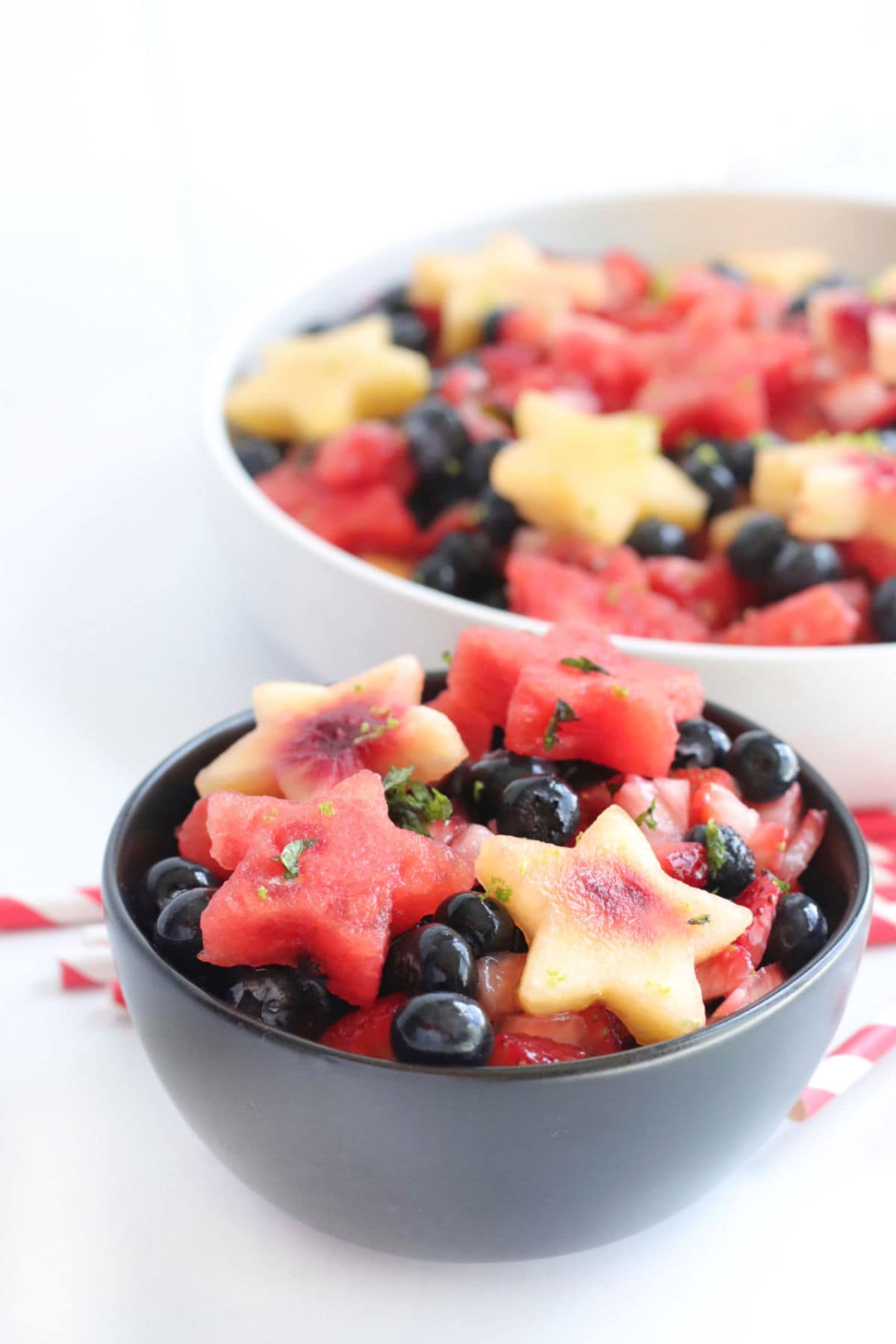 Side view of two bowls of fruit salad.