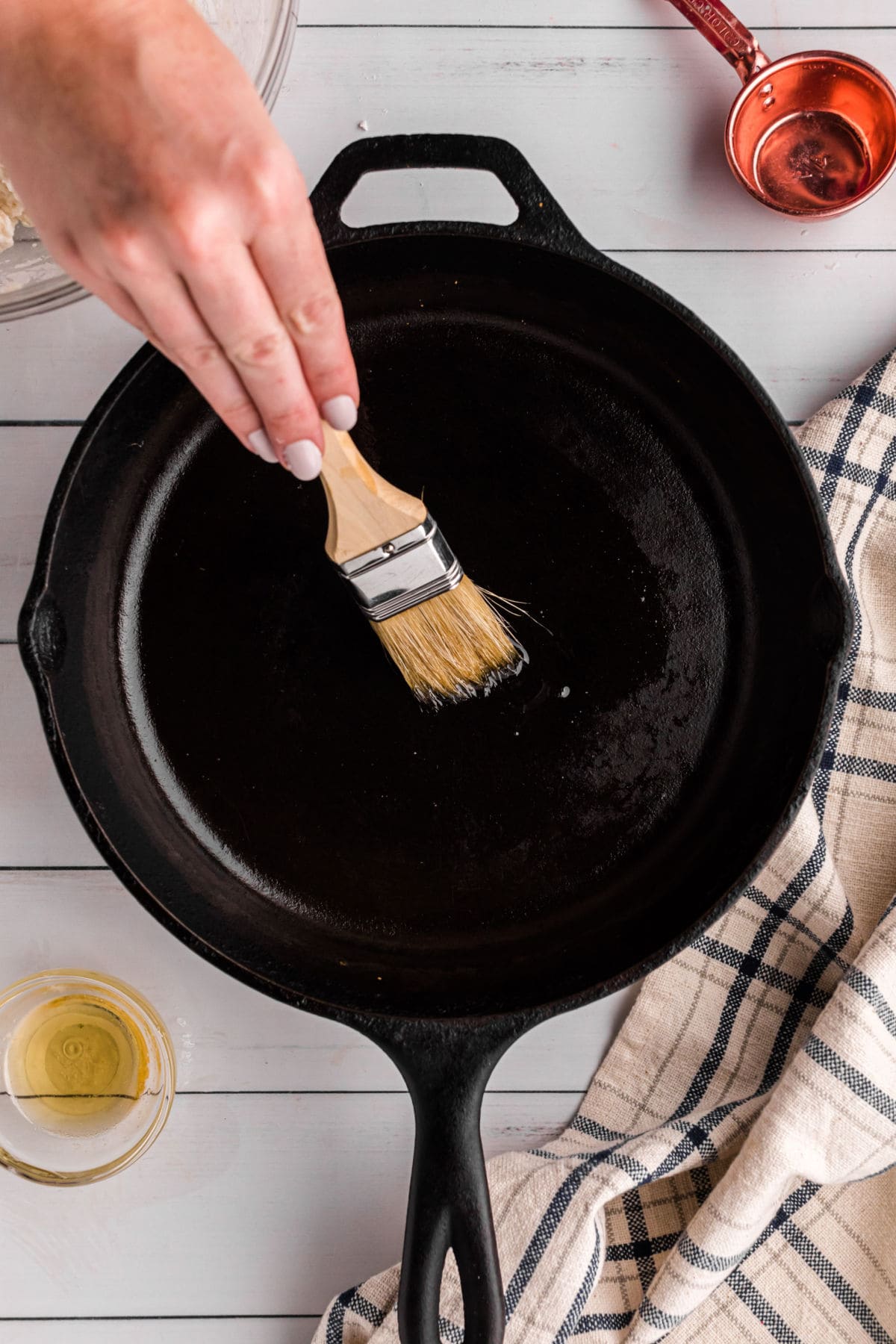 Some one seasoning an iron skillet with oil
