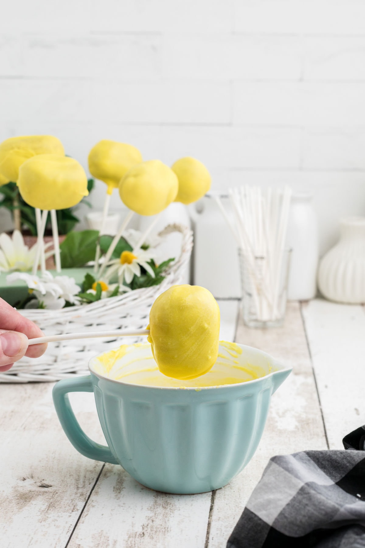 Showing how to dip the formed cake into the yellow candy coating.