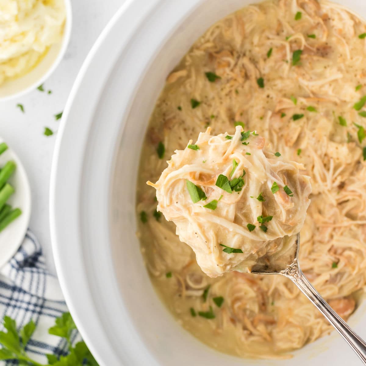 Closeup of a serving spoon filled with chicken and gravy for the feature images.