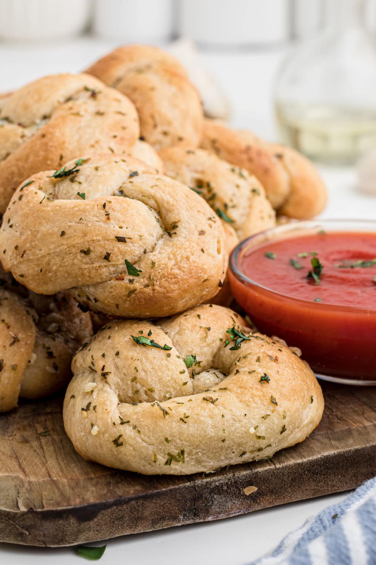 A pile of garlic knot rolls on a table.