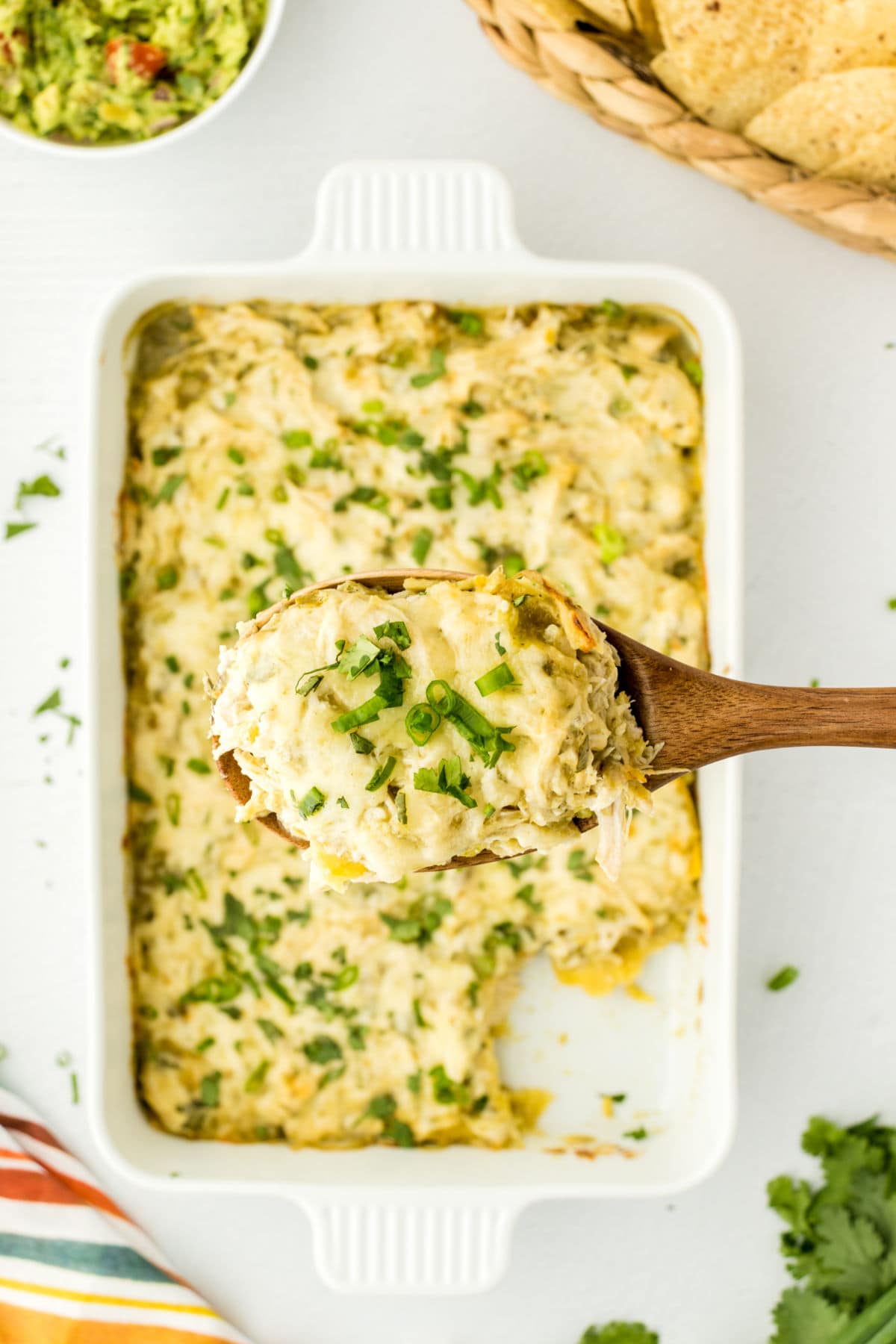 A serving of enchilada casserole being removed from the plate.