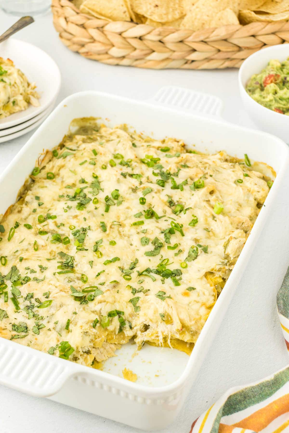 Sour cream chicken enchilada casserole with a serving removed.