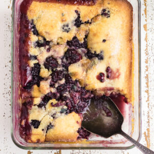 Closeup of blackberry cobbler with a spoon in it.