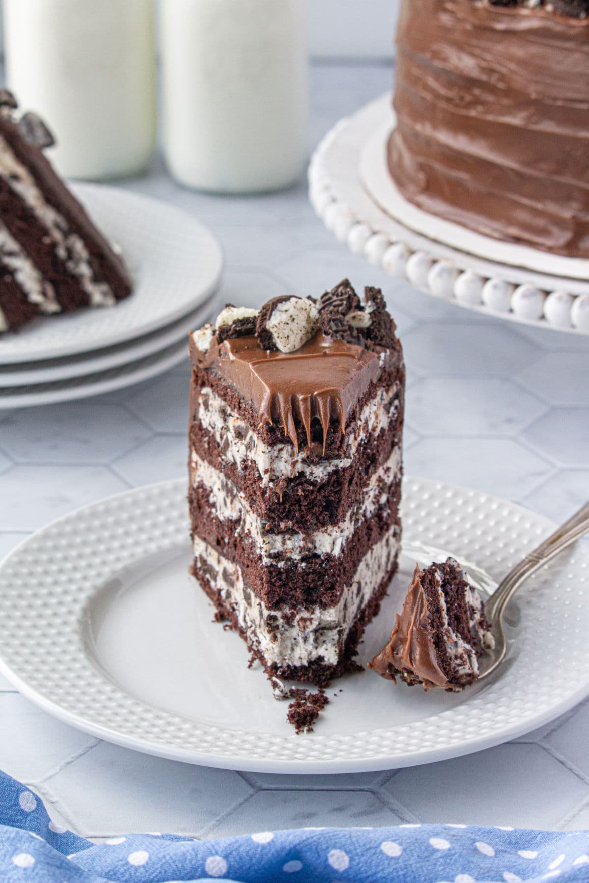 A slice of cake on a white plate with a fork next to it.