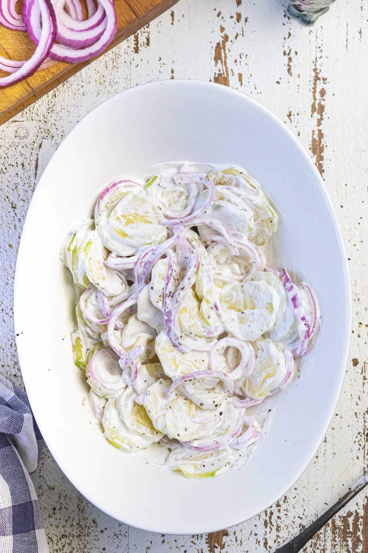 Overhead view of a bowl of creamy cucumber salad.