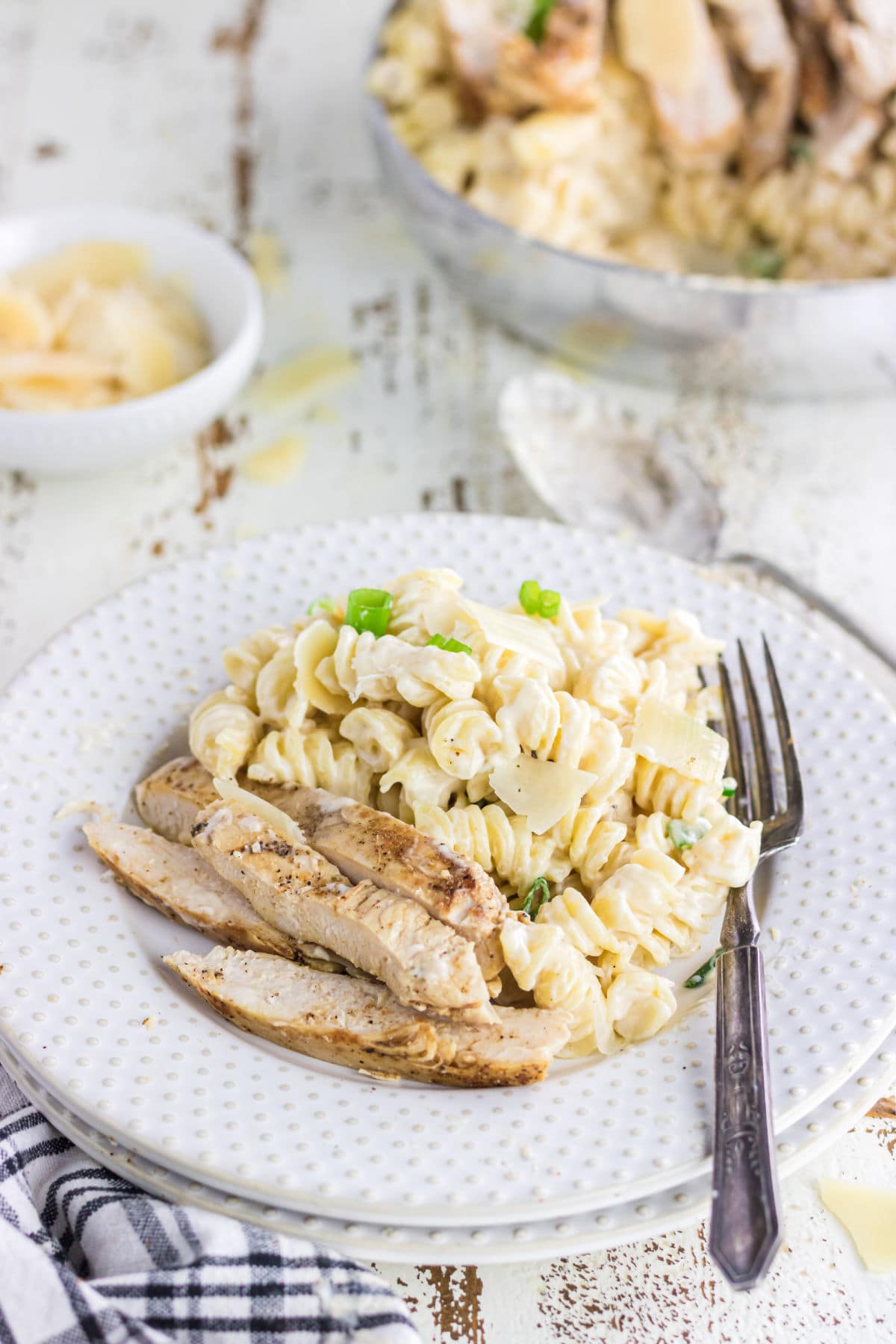 Creamy white sauce covers rotini pasta with grilled chicken on top.