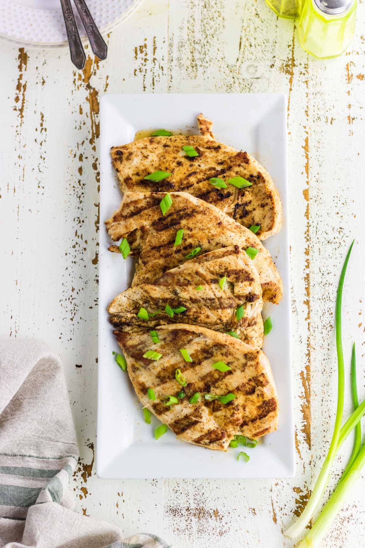 Overhead view of the grilled chicken on a white platter.