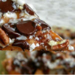 Nachos covered in melted chocolate, caramel sauce, and pecans.