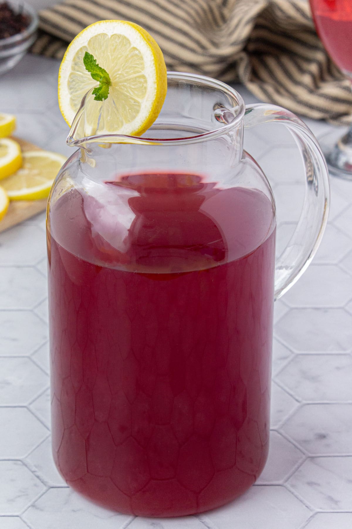 A pitcher with red hibiscus lemonade in it.