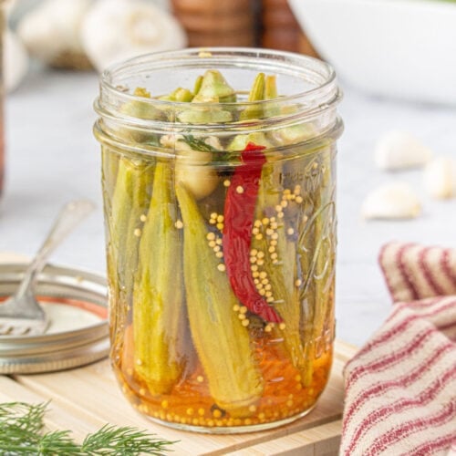 A closeup of a finished jar of pickled okra.