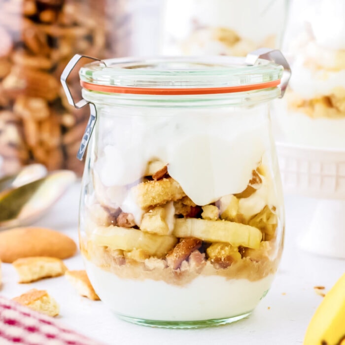 Closeup of a jar with layers of. yogurt and banana in it.