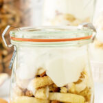 Layers of yogurt and bananas in a jar with a text overlay for Pinterest.