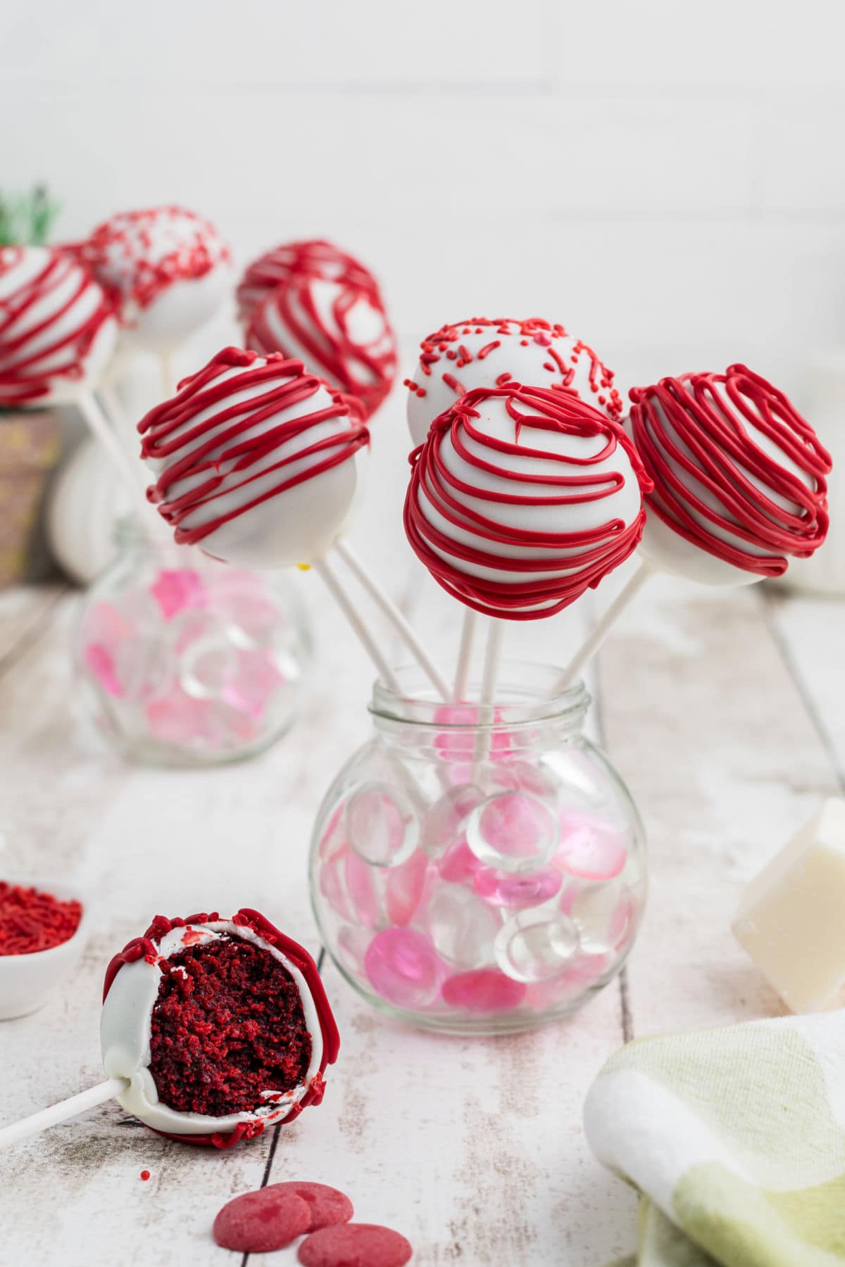 White chocolate dipped cake pops with red decorating.