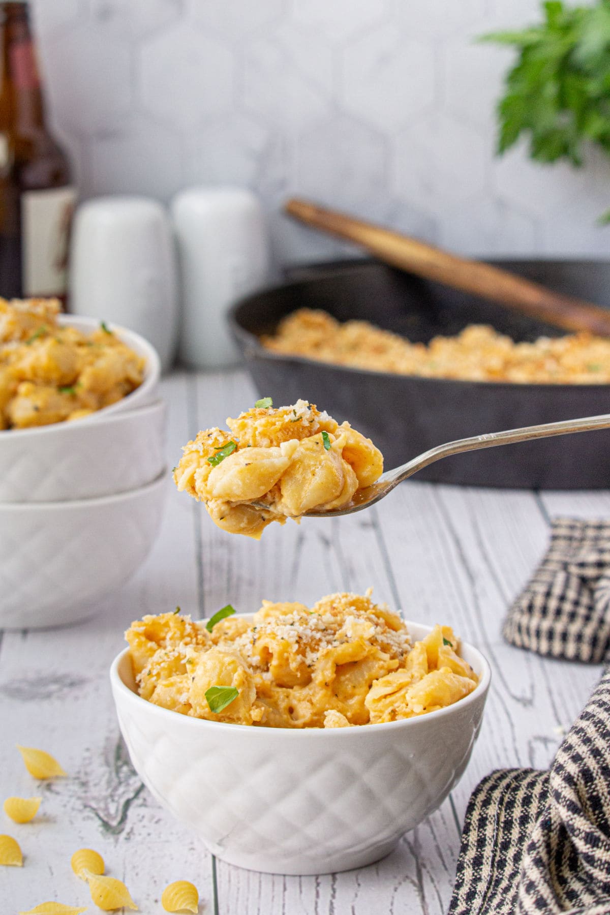 A spoon lifting a scoop of macaroni and cheese out of a bowl.