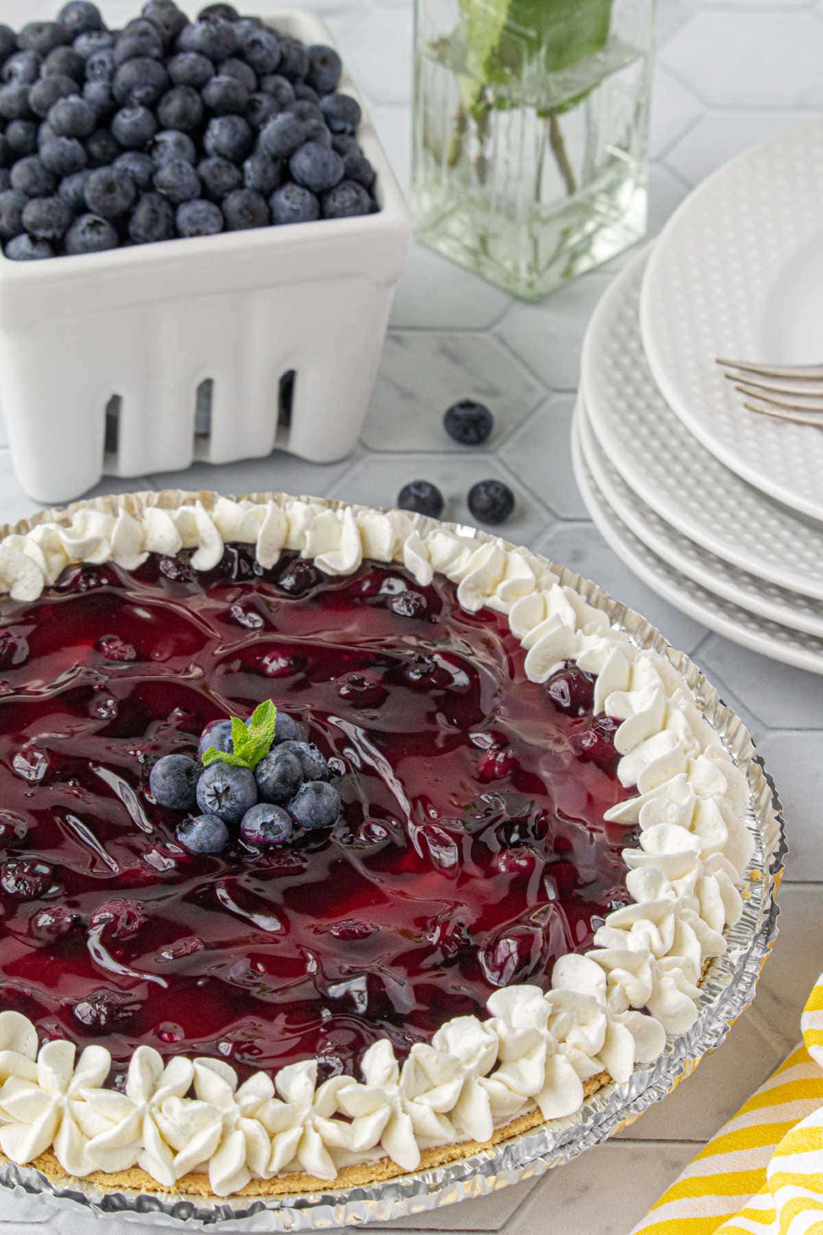 Whole blueberry cheesecake pie on a table.
