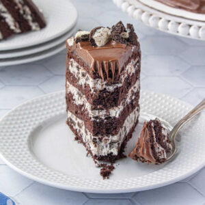 A closeup of a slice of cake with Oreo cookies and cream cake filling.
