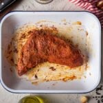 A seasoned steak in an enamel dish ready to cook.