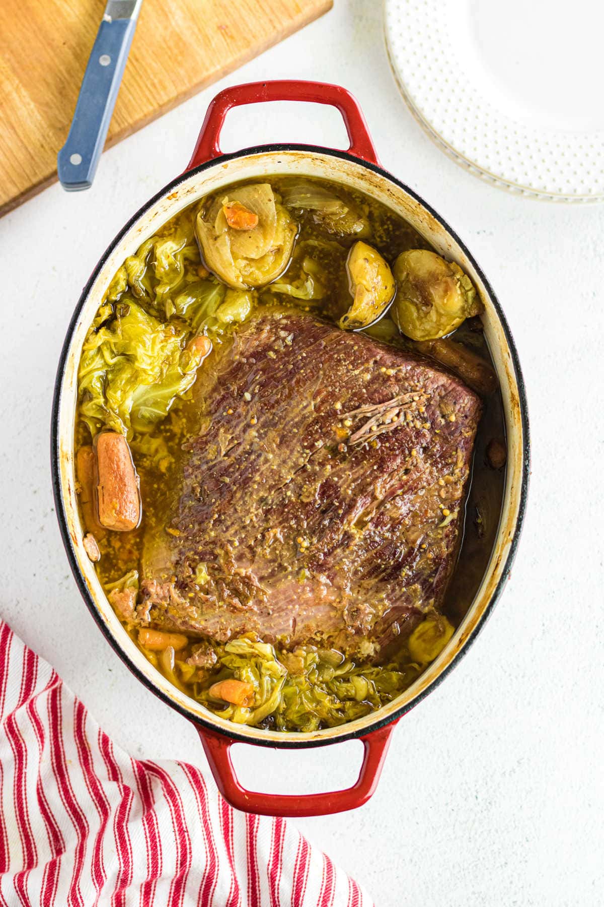 Overhead view of cooked corned beef in a red Dutch oven.