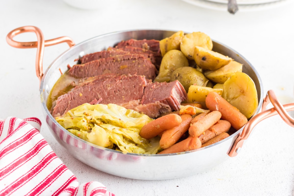 Closeup of corned beef and vegetables in a serving dish.