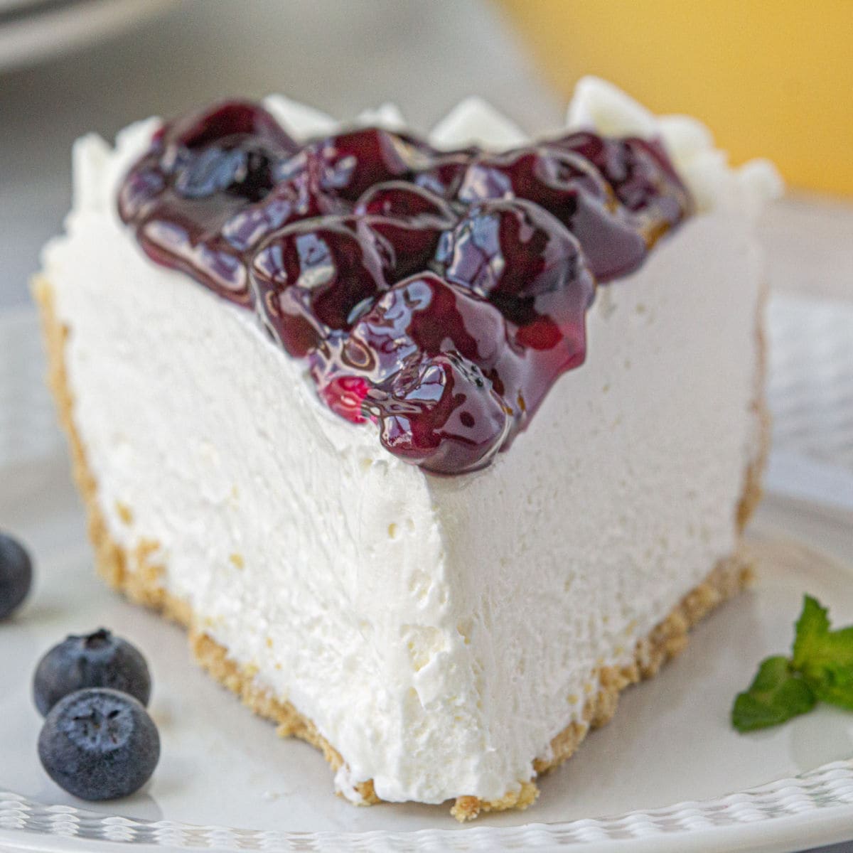 Closeup of a slice of cheesecake showing the sweet blueberry topping.