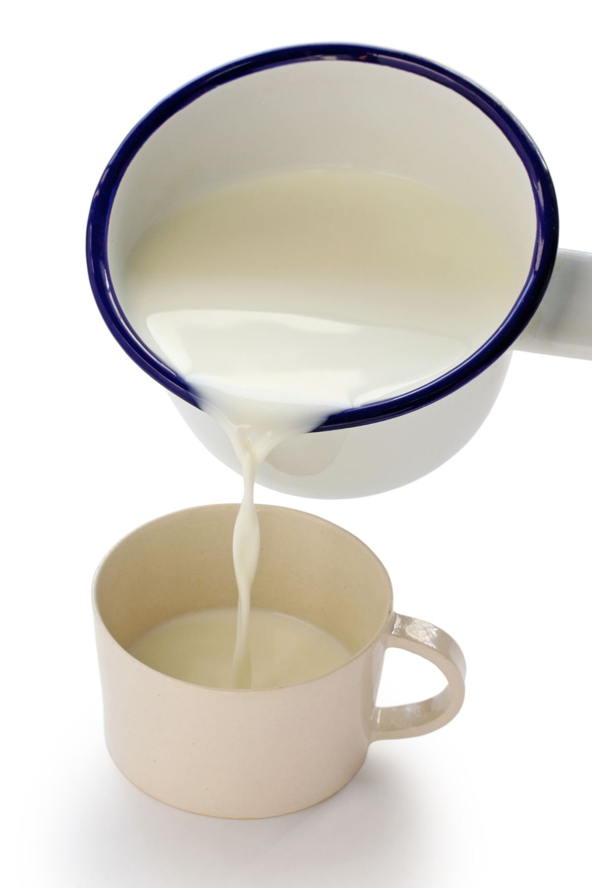 A pan pouring hot milk into a cup.
