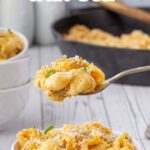 A spoonful of mac and cheese being lifted from the dish with a text overlay for Pinterest.