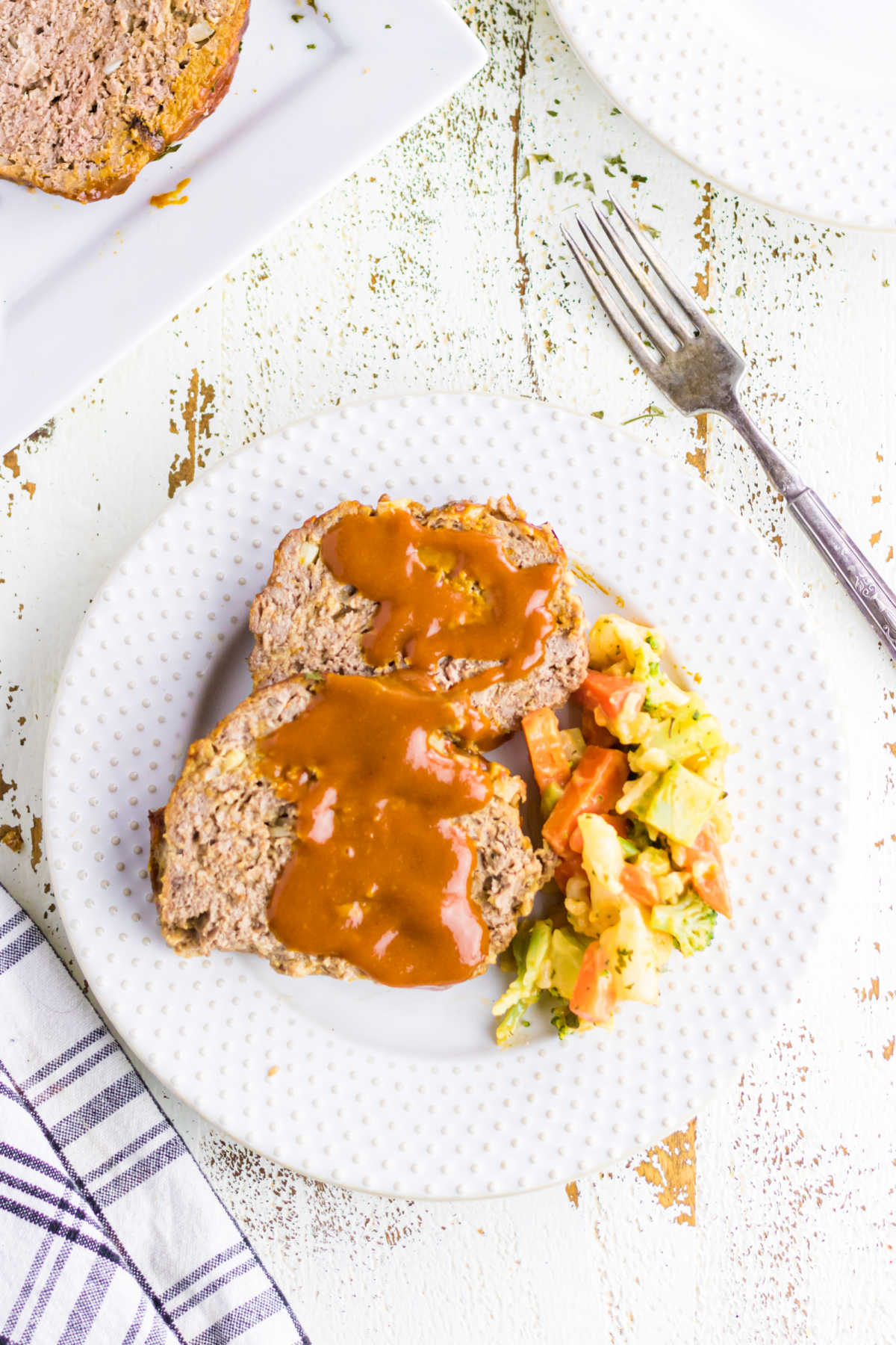 Overhead view of slices of meatloaf with sauce on them.