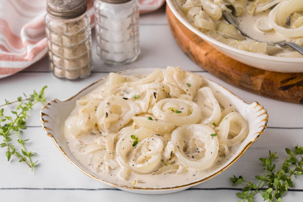 Bowl of creamed onions on a table.